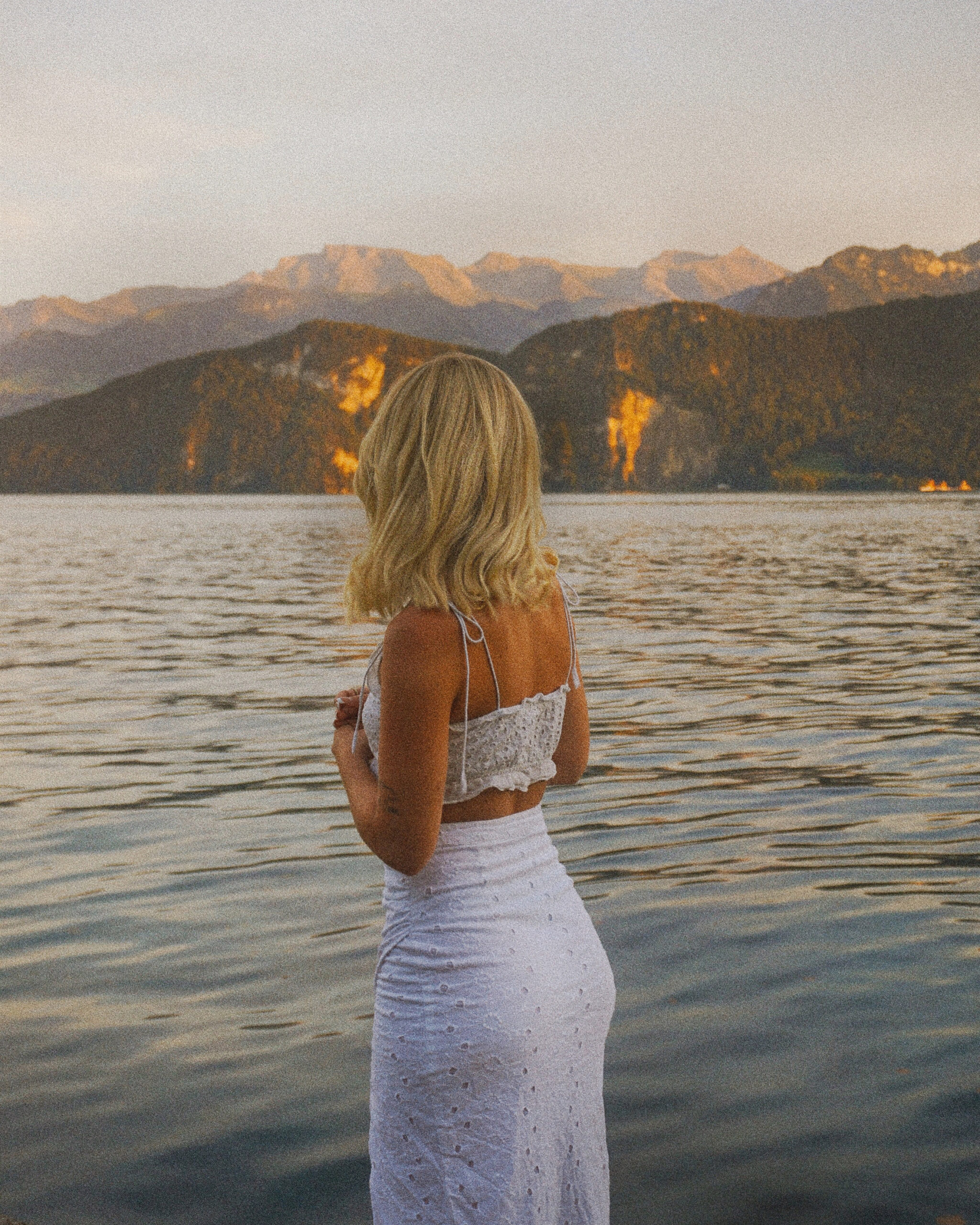 Young woman gazing at a peaceful beach, enjoying a serene moment during her solo travel adventure.